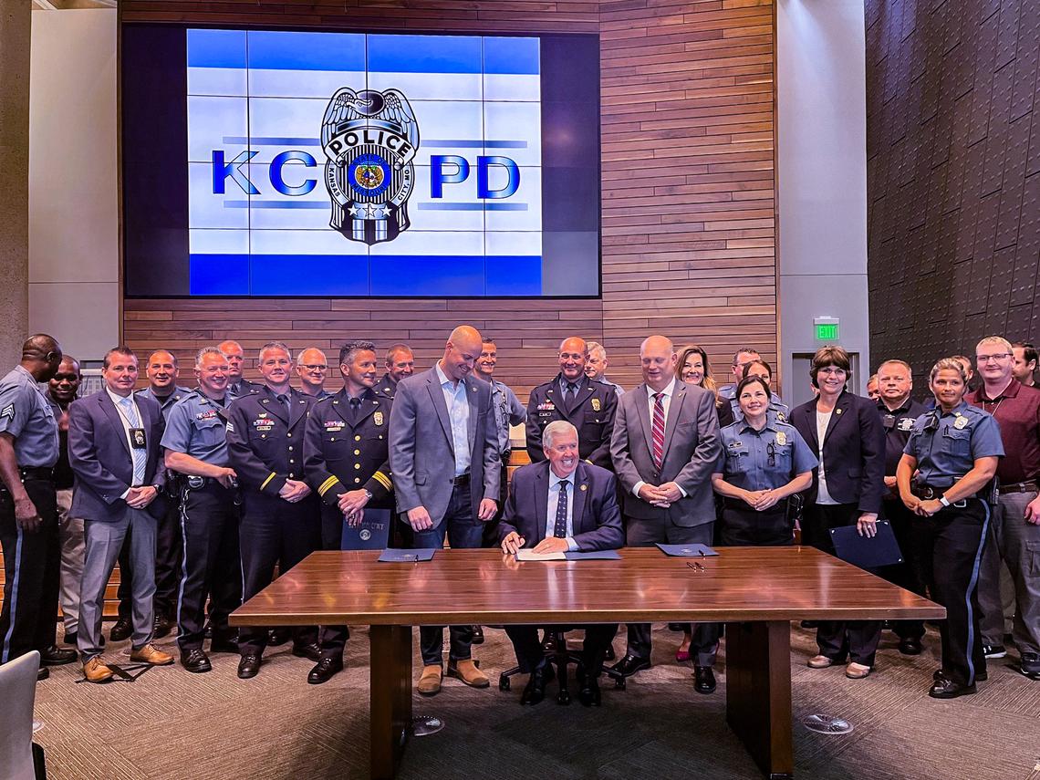 Missouri Gov. Mike Parson at a ceremonial bill signing with members of the Kansas City Police Department.
