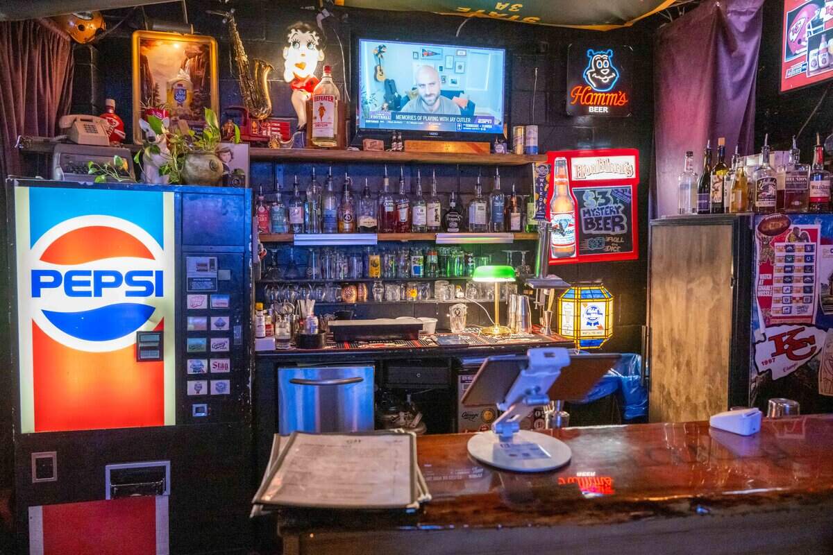 A bar area with alcohol, beer, and wine, inside Gnarly Hussle, a vintage clothing store in Raytown.