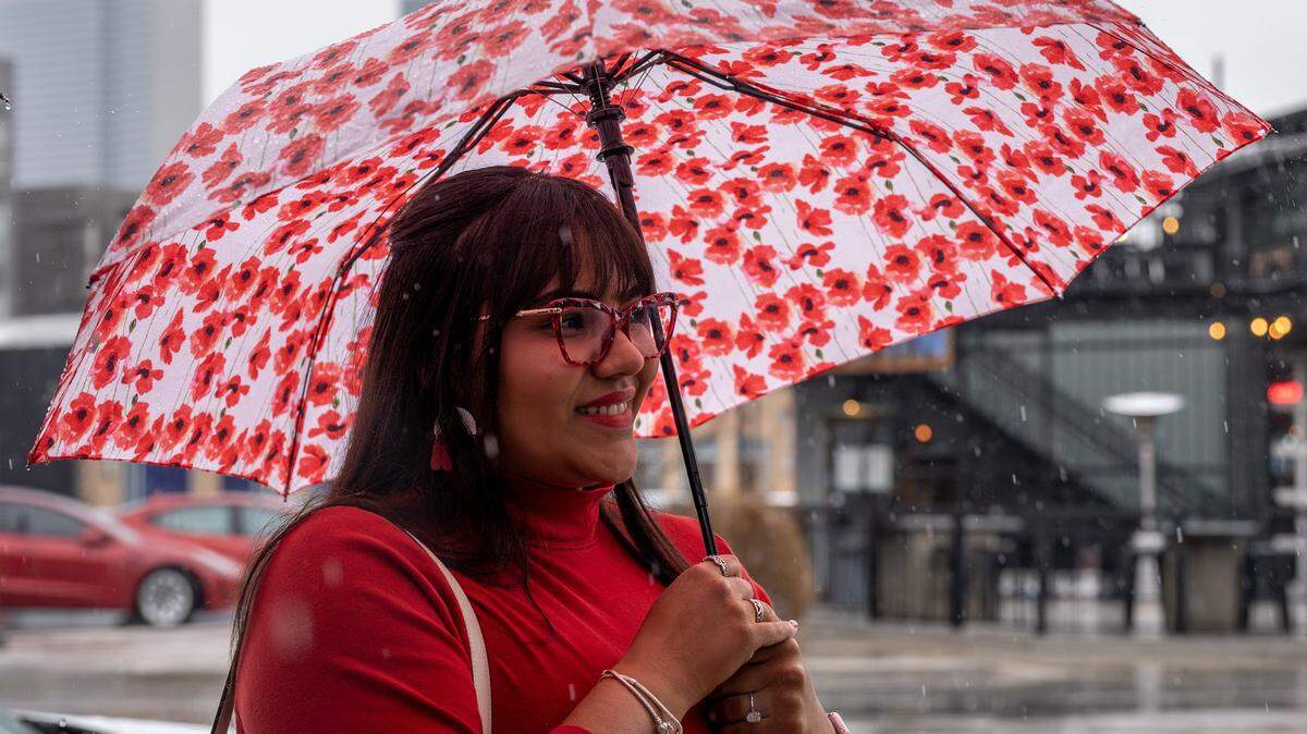 Laura Santosa holds an umbrella while waiting in line outside Café Corazón on Saturday, Feb. 14, 2026, in Kansas City.