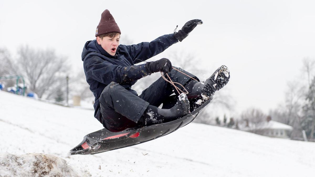 Declan Kearns sleds off a jump he made with a friend on Wednesday, Jan. 25, 2023, in Kansas City.