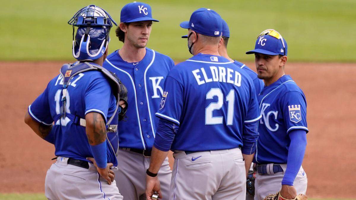 Kansas City Royals pitching coach Cal Eldred (21) talks with starting pitcher Daniel Lynch after Lynch gave up four runs during the second inning of a baseball game against the Detroit Tigers, Thursday, May 13, 2021, in Detroit. (AP Photo/Carlos Osorio)