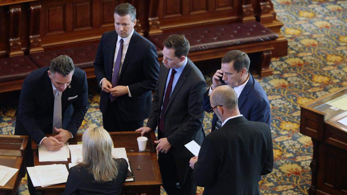 Fellow Kansas state senators and Senate staffers confer with Sen. Alicia Straub, R-Ellinwood, at her desk, during a break in a debate on proposals aimed at financially protecting workers who refuse to comply with federal COVID-19 vaccine mandates, Monday, Nov. 22, 2021, at the Statehouse, in Topeka, Kan. The others in the photo are, clockwise from the left, Senate President Ty Masterson, R-Andover; Senate Secretary Corey Carnahan; Masterson chief of operations Chase Blasi; Sen. Dennis Pyle, R-Hiawatha, and Sen. Mark Steffen, R-Hutchinson.