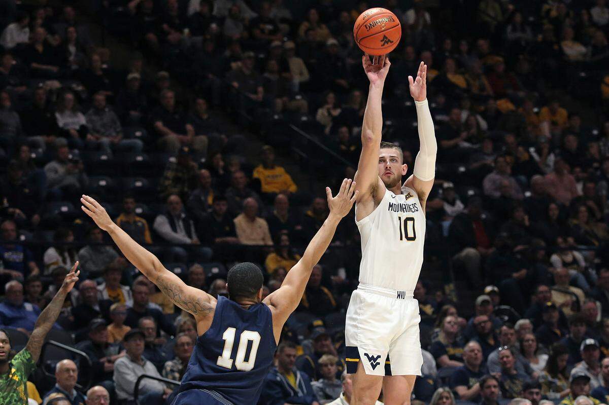 West Virginia guard Erik Stevenson shoots while defended by Navy guard Christian Jones during the second half in Morgantown, W.Va., on Wednesday, Dec. 7, 2022.