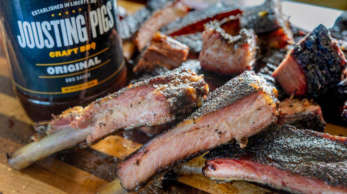 John Atwell, co-owner of Jousting Pigs BBQ in Liberty, is expanding, taking over the former Arthur Bryants restaurant at 1702 Village West Parkway. Sliced ribs and burnt ends he smoked overnight in the new restaurant’s smoker are shown with their Jousting Pigs BBQ sauce.