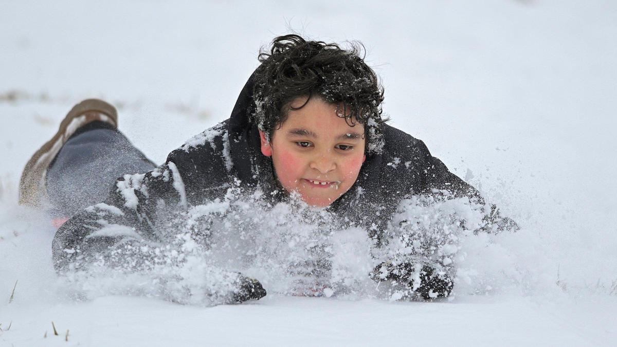 Nine-year-old Jace Stoddard of Kansas City sleds down a hill at Gillham Park. The two to four inches of snow that fell in the Kansas City area Saturday morning, Jan. 15, 2022, brought people out to play and enjoy the snow.