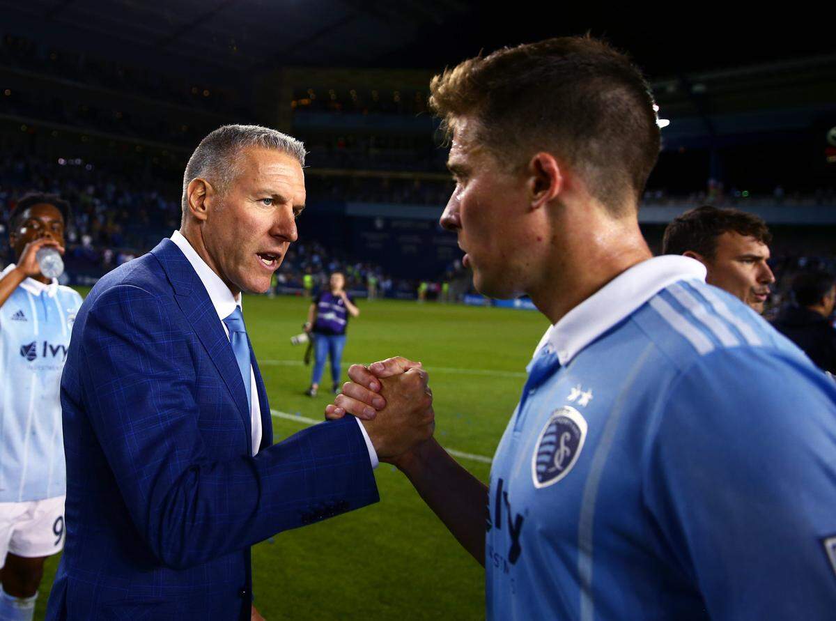 Sporting KC manager Peter Vermes (left) celebrates with defender Matt Besler after defeating the Seattle Sounders at Children’s Mercy Park on May 17, 2017.