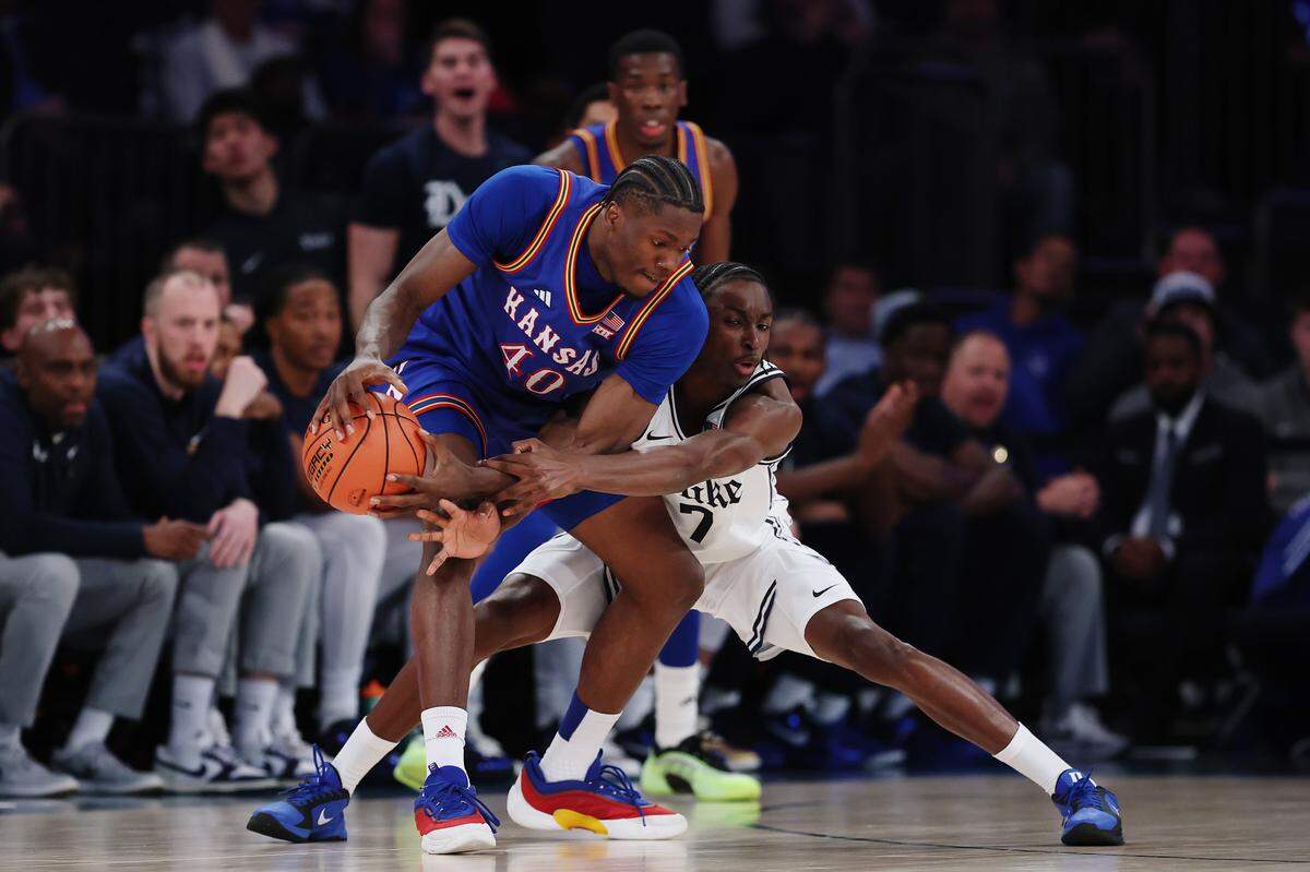 Flory Bidunga #40 of the Kansas Jayhawks dribbles against Dame Sarr #7 of the Duke Blue Devils during the first half in the 2025 State Farm Champions Classic at Madison Square Garden on November 18, 2025 in New York City.
