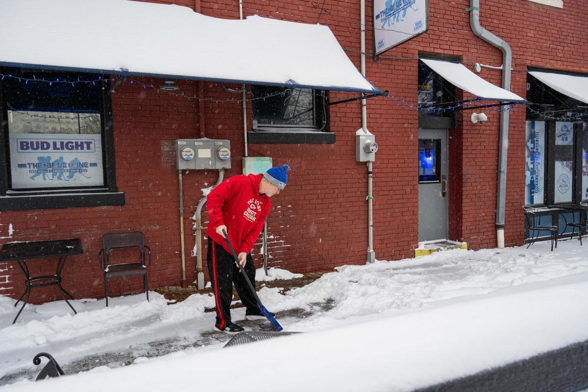 Steve Stegall shovels snow outside The Blue Line in the River Market in Kansas City on Sunday, Jan. 5, 2025. The Blue Line is one of few Kansas City establishments open in the area.
