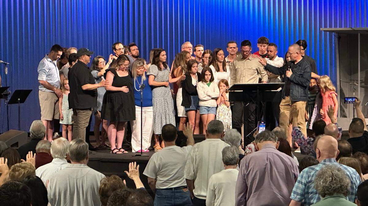 Members of the International House of Prayer-Kansas City’s Forerunner Church worship team gather to pray with senior pastor Isaac Bennett on May 19 as the church holds its final service in Grandview. IHOPKC has been in turmoil since its founder, Mike Bickle, was accused last year of sexually abusing multiple women.