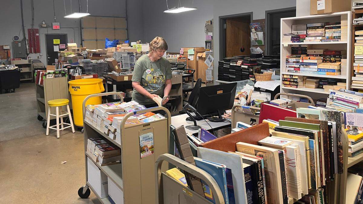 Karin Dembinski, sorting and sales specialist with the Friends of Johnson County Library, works through some of the inventory waiting to be placed on sale.
