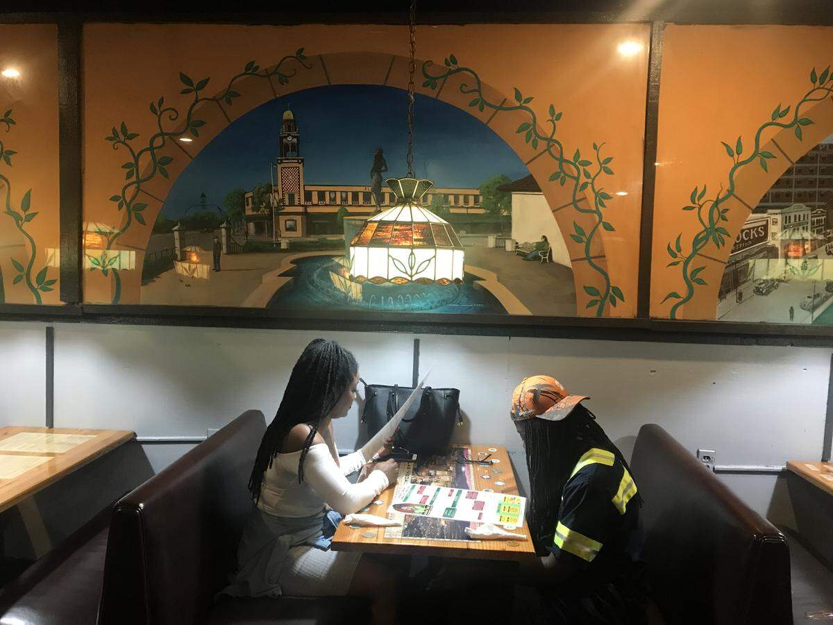 Customers dine below murals of famous Kansas City sites — from the Plaza to Mama Tio’s.