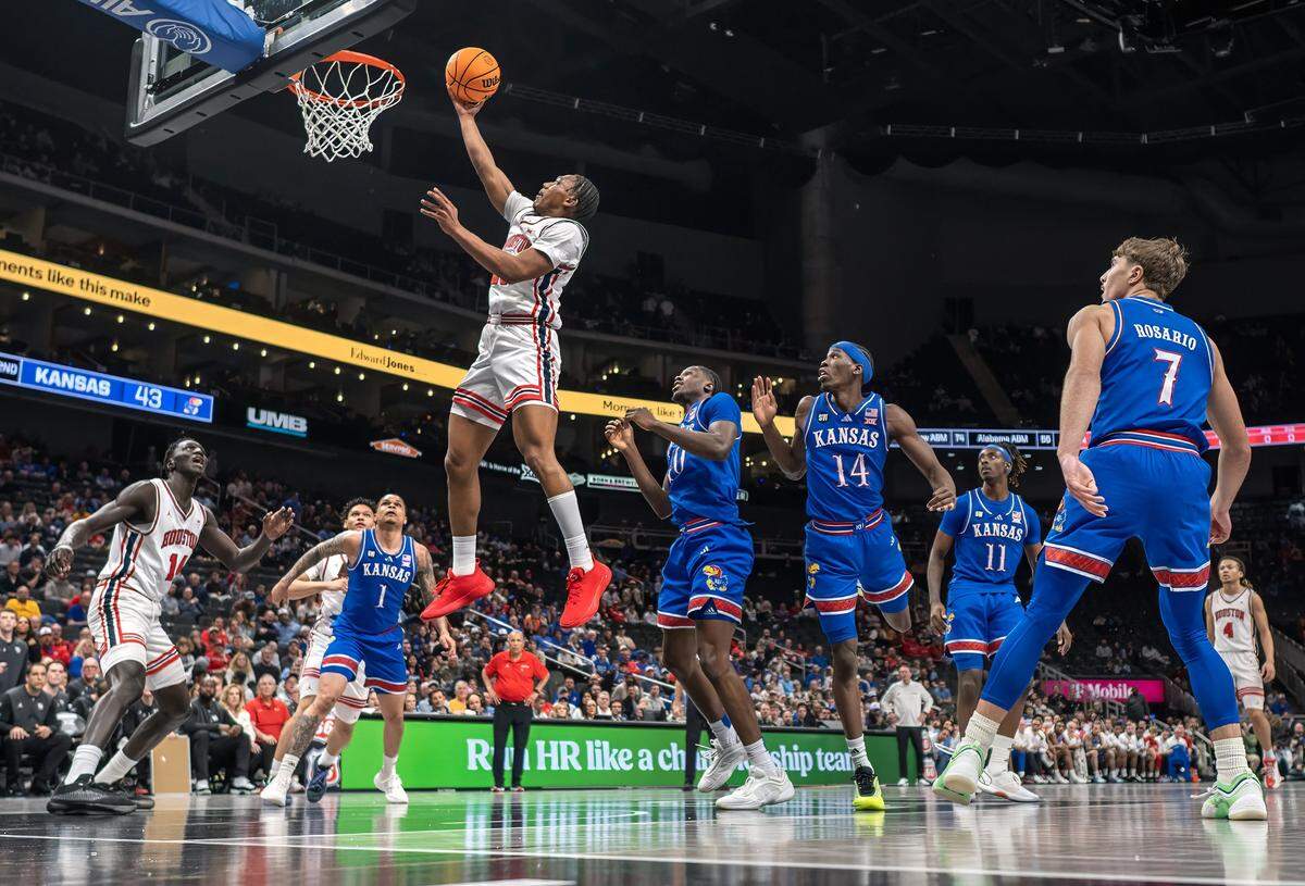 Arizona Wildcats forward Sidi Gueye (15) goes for a layup as Kansas Jayhawks forward Flory Bidunga (40) and Kansas Jayhawks guard Melvin Council Jr. (14) and others look on in the second half at the Big 12 Men's Basketball Tournament at T-Mobile Center on Friday, March 13, 2026, in Kansas City. Houston defeated Kansas, 69-47.