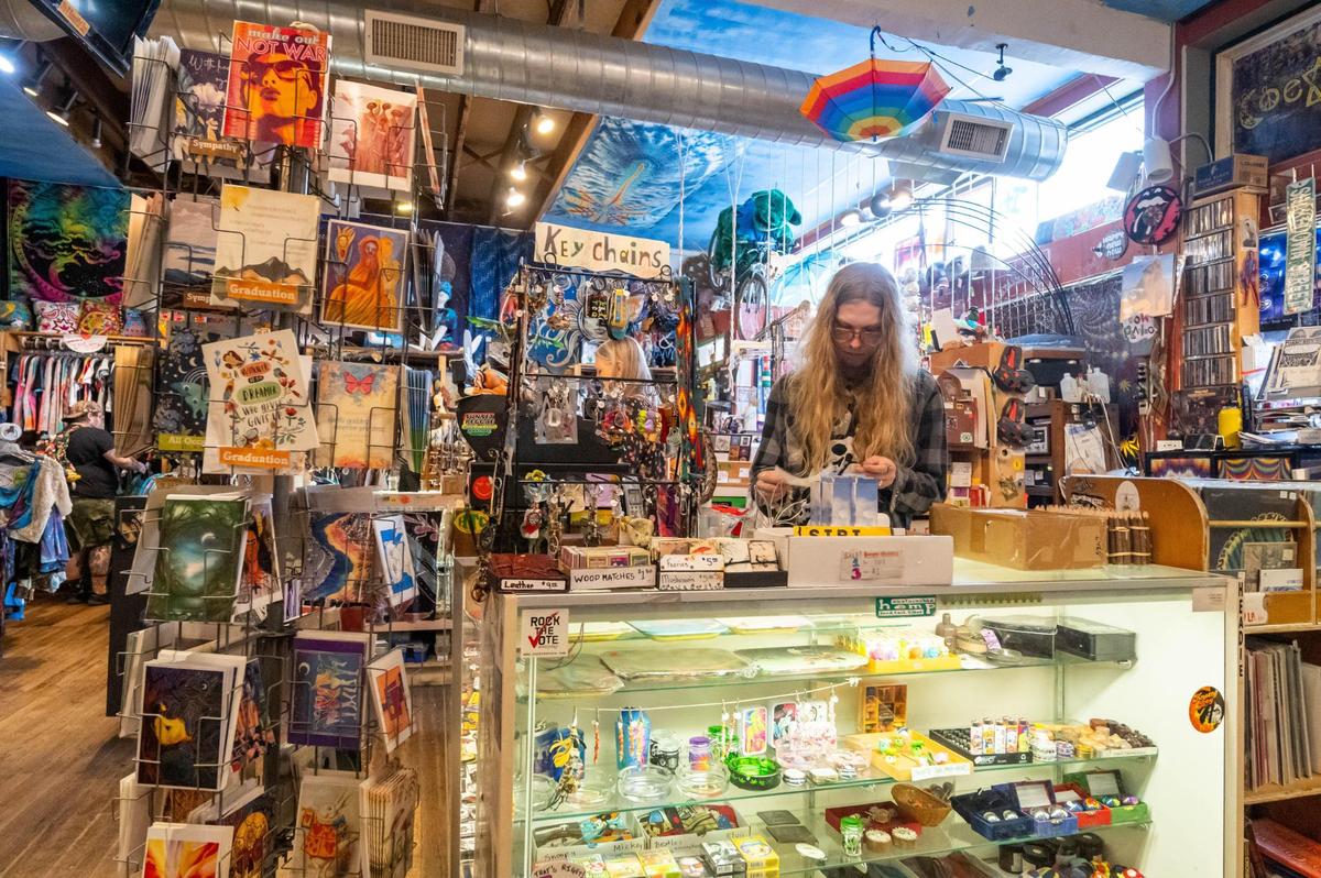 Reed Branstetter works the counter at It’s a Beautiful Day, a boutique shop near 39th Street and Broadway in Kansas City on Wednesday. The shop is covered from top to bottom with hippie memorabilia and references to classic bands and aliens.