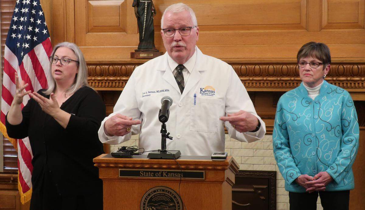 Dr. Lee Norman of the Kansas Department of Health and Environment said he would not be surprised if the state’s coronavirus cases number in the hundreds within a month. At a recent press conference he was flanked by Gov. Laura Kelly, right, and an interpreter.
