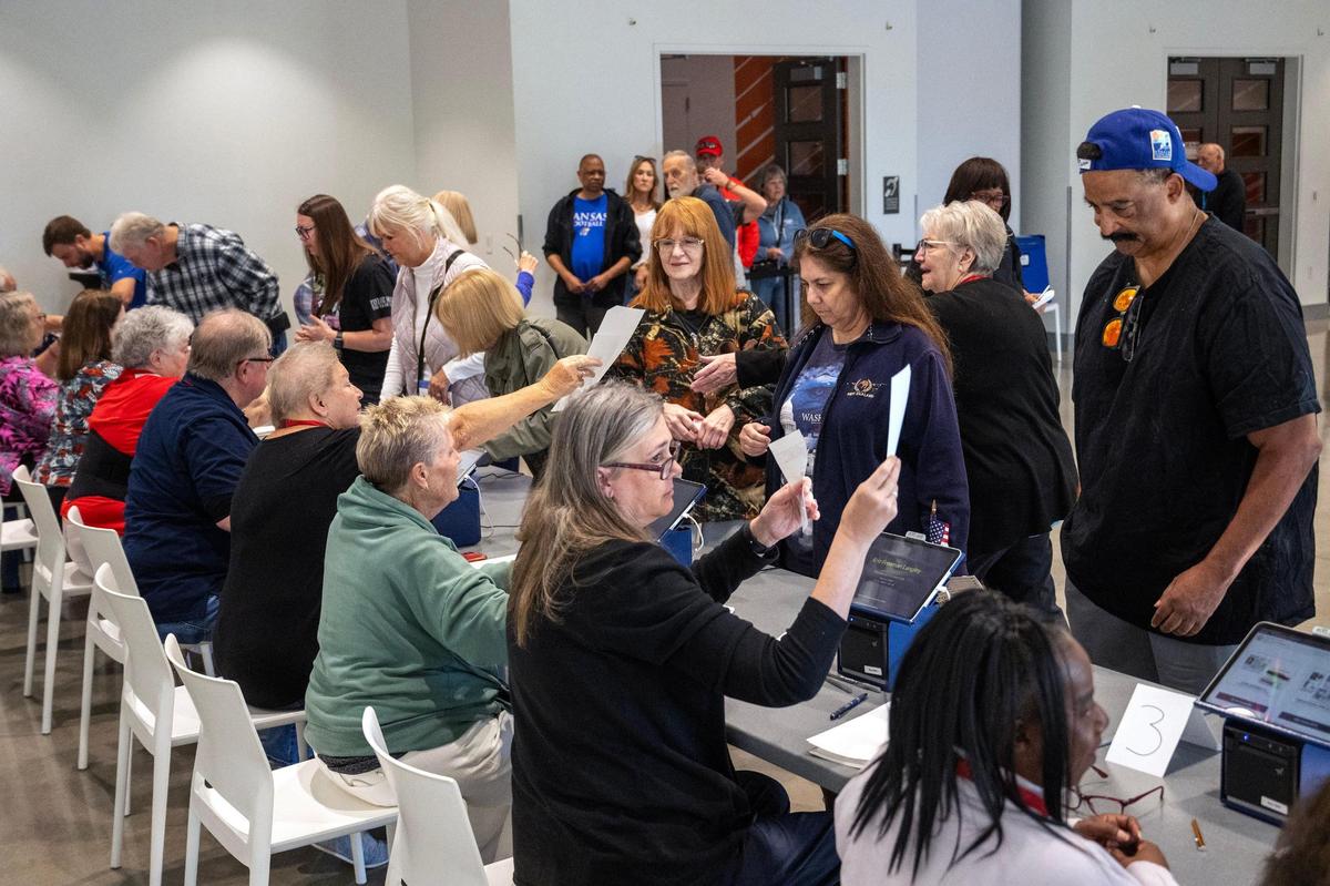 Within minutes of the doors opening, election workers were swamped by the large turnout of Johnson County residents arriving for the first day of in-person advance voting for the 2024 General Election at The Arts and Heritage Center in Overland Park on Saturday, October 19, 2024.