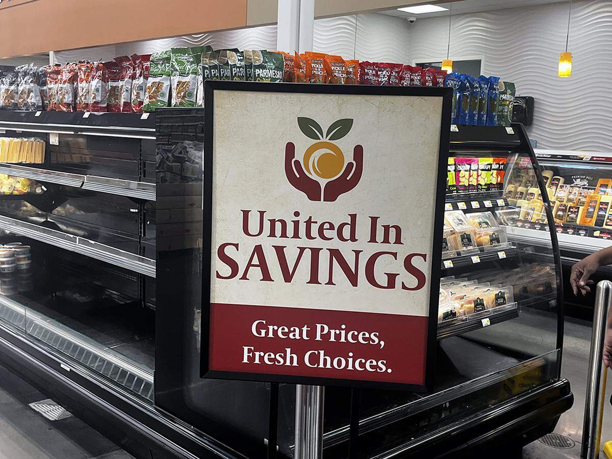 Signs at the new United Market tout its products and prices.