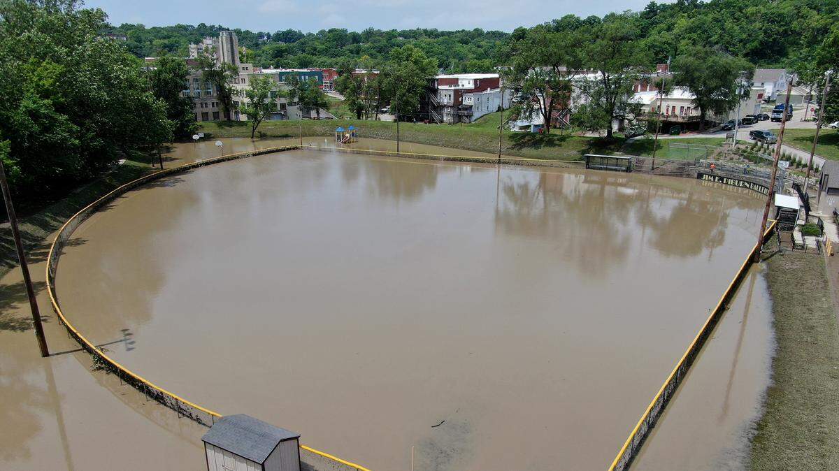 The Jim Piburn Ball Field in Excelsior Springs was completely flooded Friday, June 25, 2021, after storms passed through Thursday night. More storms are expected Friday. Workers attempted to clean up the dugouts.