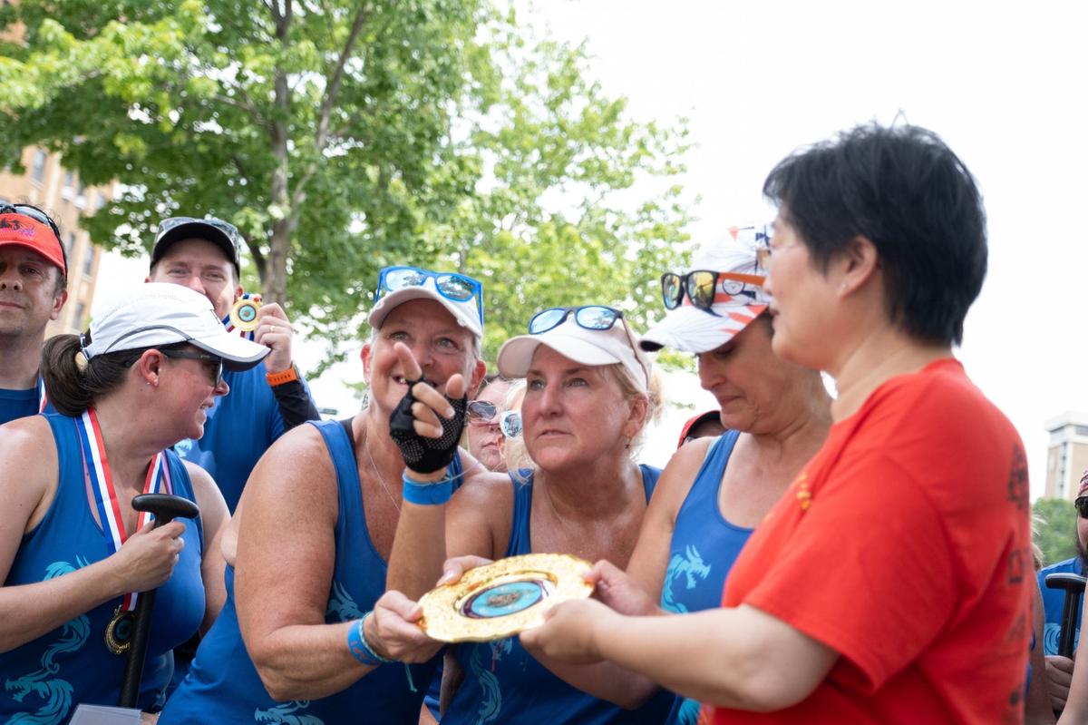 SLAP Dragons team members accept their award for placing first in the races at the 18th annual Kansas City Dragon Boat Festival.