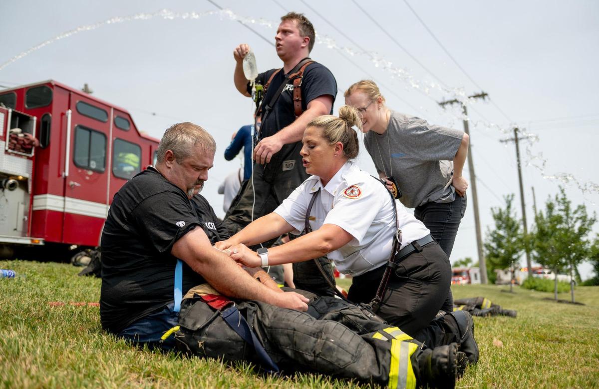 A firefighter receives an IV after battling a blaze at Pioneer Pallet in the 3500 block of Nicholson Ave. on Thursday, June 15, 2023, in Kansas City.