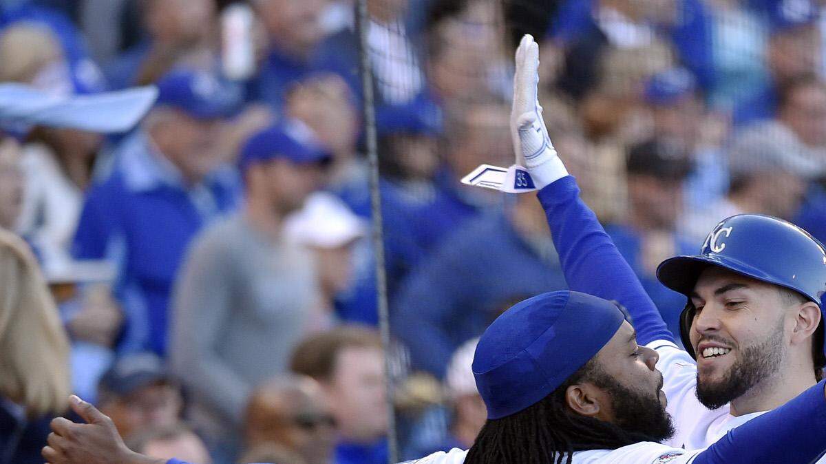 Kansas City Royals starting pitcher Johnny Cueto celebrates with first baseman Eric Hosmer after Hosmer scored when catcher Salvador Perez was walked with the bases loaded in the sixth inning during Friday's ALDS baseball game on October 9, 2015 at Kauffman Stadium in Kansas City, Mo.
