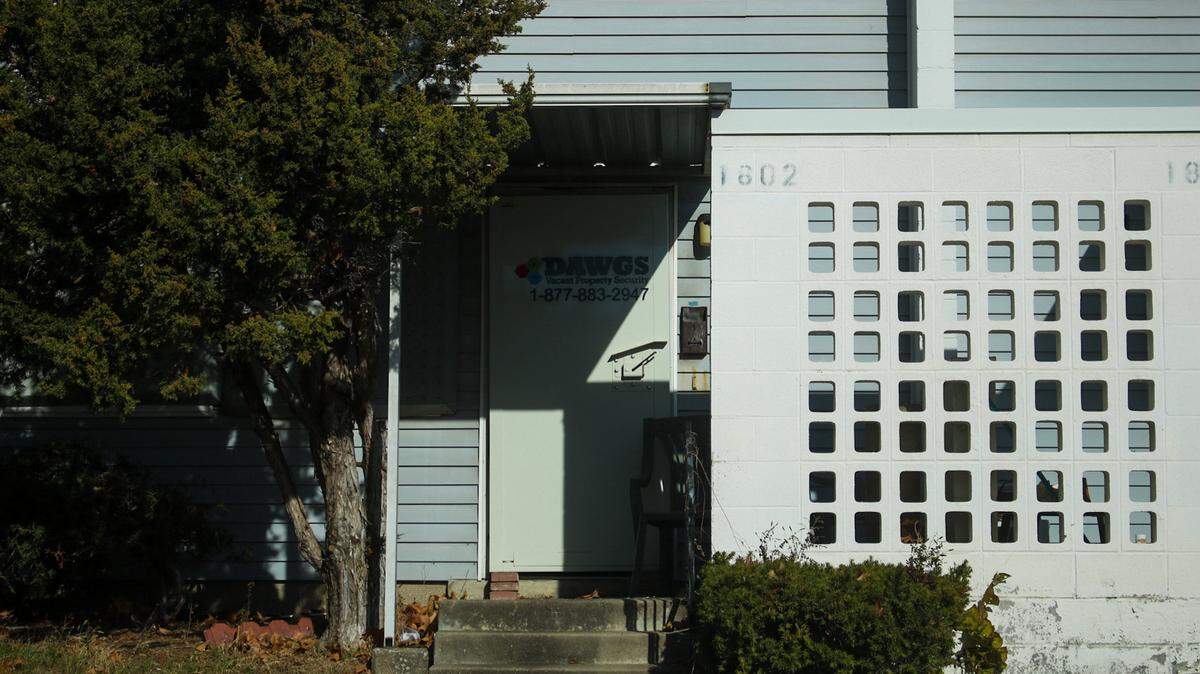 A sign for DAWGS Vacant Property Security is seen on the door of a vacant apartment in the Parade Park Homes complex on Dec. 9, 2025.