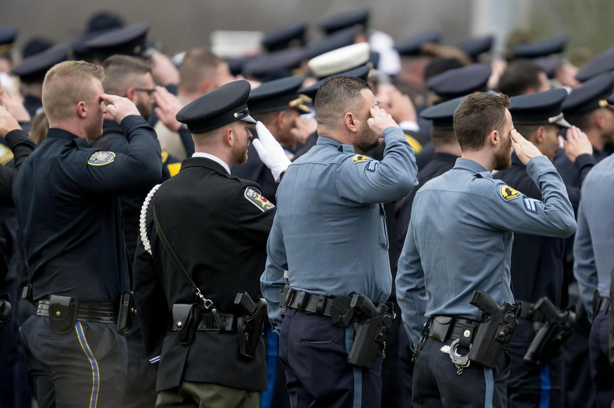 Law enforcement officers salute the casket of Independence police officer Cody Allen on Friday, March 8, 2024, in Independence. Allen was fatally shot during an eviction in northeast Independence last week.