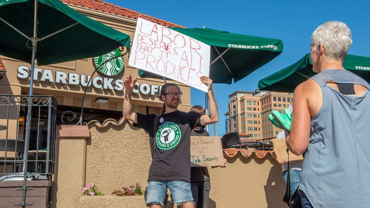 While Starbucks employee Josh Crowell picketed outside the Starbucks Country Club Plaza location Tuesday, a customer stopped to ask for any details on why the location had closed. Monday afternoon the store notified employees and guests that the location had permanently closed according to signs posted on the doors.
