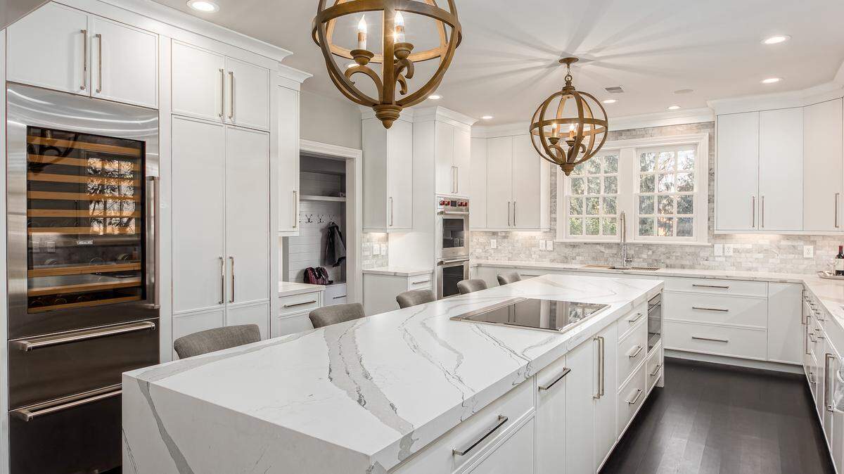 If the kitchen is the heart of the home, Karin Ross knows how to make it beat with clean lines and functionality rendered beautifully. This spacious breakfast bar features an inlaid range top.