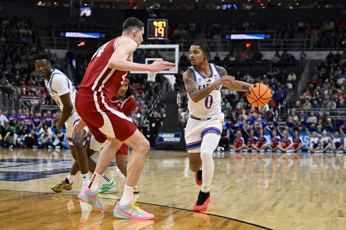 Kansas Jayhawks guard Shakeel Moore, right, confronts towering Arkansas Razorbacks forward Zvonimir Ivisic during a first-round NCAA Tournament men’s basketball game at Amica Mutual Pavilion in Providence, Rhode Island, on Thursday, March 20, 2025.