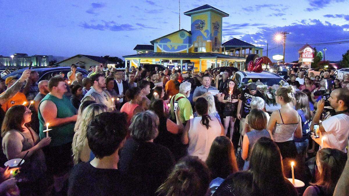 Mourners gathered in the parking lot of the Ride the Ducks offices during Friday’s candlelight vigil for the victims of the Branson duck boat tragedy on Table Rock Lake.