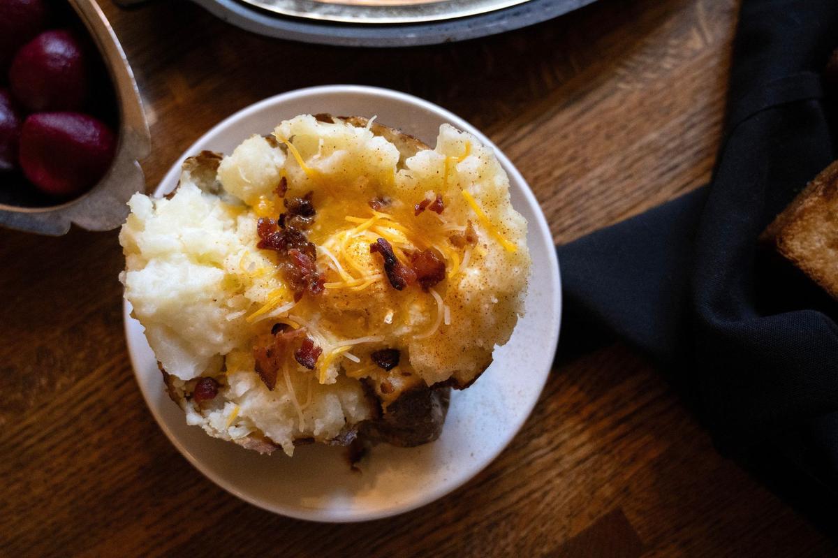 A twice-baked potato topped with cheese and bits of bacon is served at Jess and Jim’s Steakhouse.