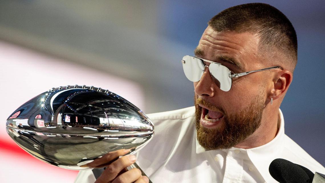 Kansas City Chiefs tight end Travis Kelce shouts while holding the Vince Lombardi Super Bowl Trophy during the NFL Draft outside of Union Station in April. Replicas of the trophy are popular with football fans.