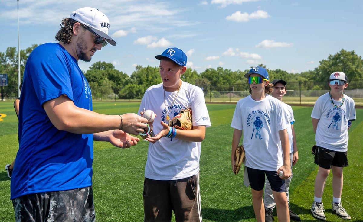 Kansas City Royals first baseman Vinnie Pasquantino returns a ball after signing an autograph as young players wait to greet him during the Vinnie Pasquantino Baseball ProCamp at Grandview High School on Thursday, July 10, 2025, in Grandview, Missouri.
