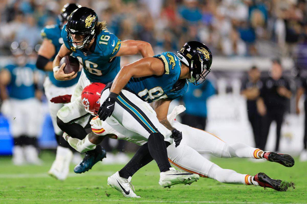 Jaguars quarterback Trevor Lawrence picks up a first down despite being draped by Kansas City Chiefs safety Bryan Cook during an NFL game at EverBank Stadium in Jacksonville, Florida on Monday, Oct. 6, 2025.