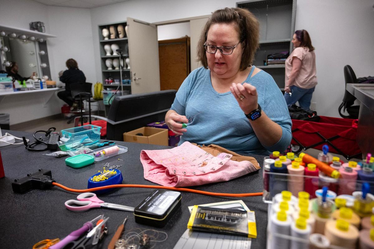Becci Jo Kelbaugh, costume shop assistant, makes adjustments to a costume for a dancer “The Nutcracker.”