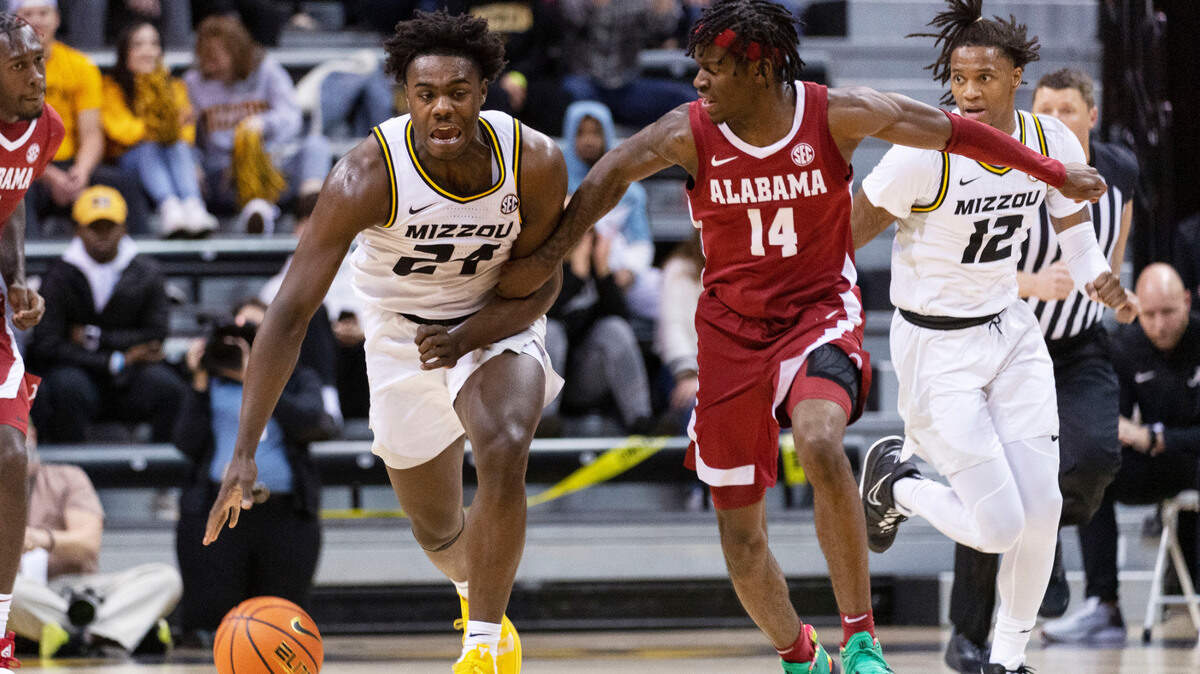 Missouri’s Kobe Brown, left, is challenged by Alabama’s Keon Ellis, right, as he dribbles during the second half of an NCAA college basketball game Saturday, Jan. 8, 2022, in Columbia, Mo. Missouri won 92-86. (AP Photo/L.G. Patterson)