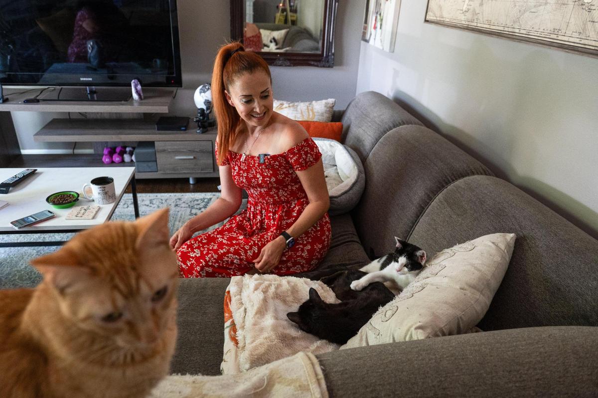Mandy Morris sits with her cats Hobbes, Willy Wonky and Charlie at her Kansas City home.