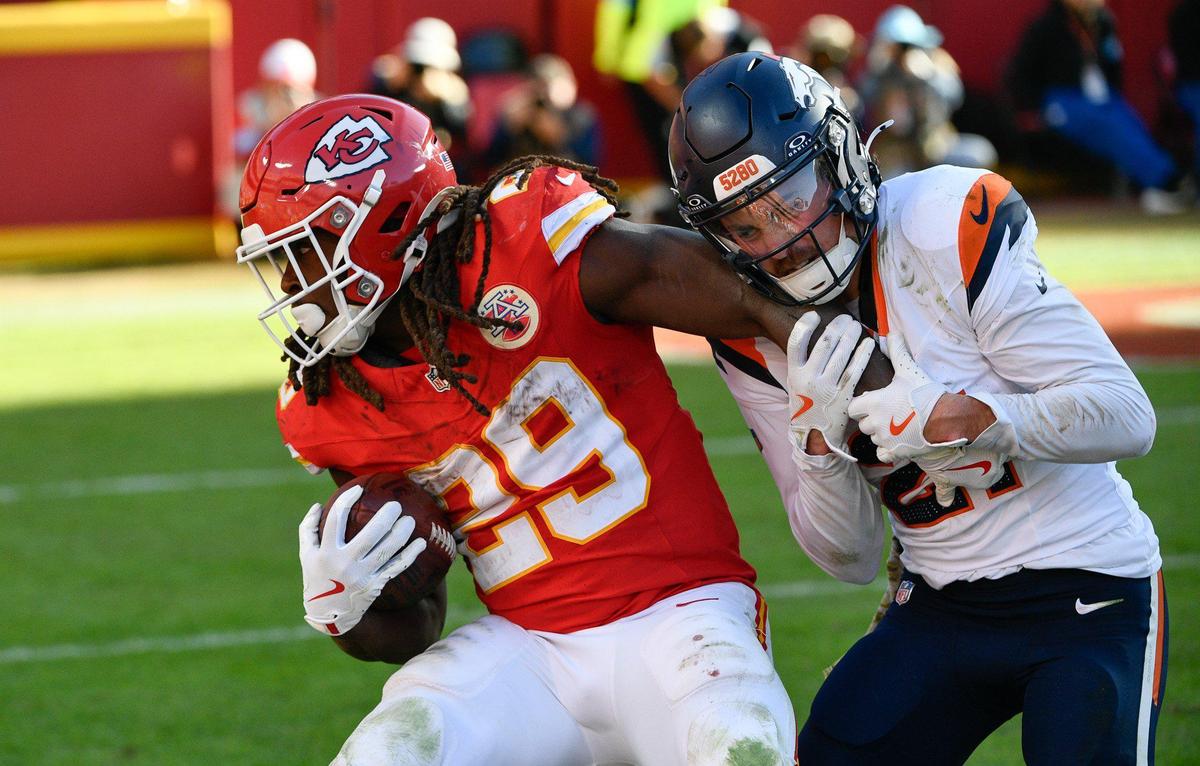 Kansas City Chiefs running back Kareem Hunt (29) attempts to break free from the grasp of Denver Broncos cornerback Riley Moss (21) after catching a pass win the second half on Sunday, Nov. 10, 2024, at GEHA Field at Arrowhead Stadium.