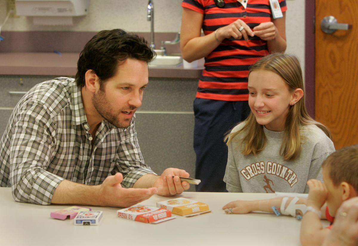 Paul Rudd explained some card playing rules to 13-year-old Kaylee Bogina and 5-year-old Isiah Lee at Children’s Mercy Hospital in Kansas City during the first press preview event for the 2010 Big Slick Poker Tournament to benefit the hospital.