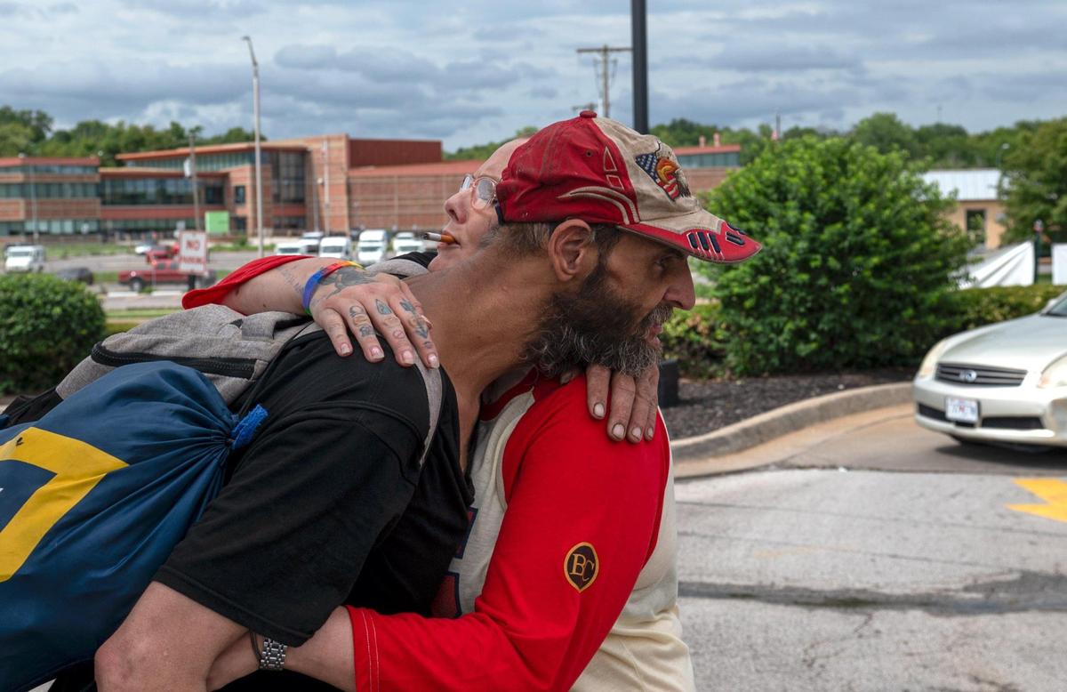 Ken Simard, left, hugs Lulu Livingston. Livingston is a long time friend of Simard and provided him with temporary housing after he was shot.