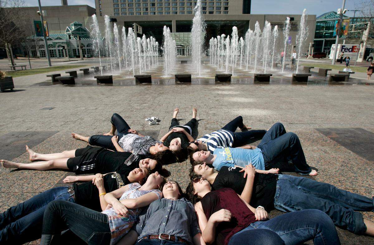 During some down time after visiting the National Archives exhibit on eugenics titled “Deadly Medicine: Creating the Master Race,” students from Lee’s Summit North High School splashed around in the fountain at Crown Center Square, and posed for several souvenir photos of their field trip, including this one. After a cold winter, people around the were out enjoying the sun and mid-60s temperatures Tuesday, Mar. 23, 2010. JILL TOYOSHIBA/The Kansas City Star. 03232010