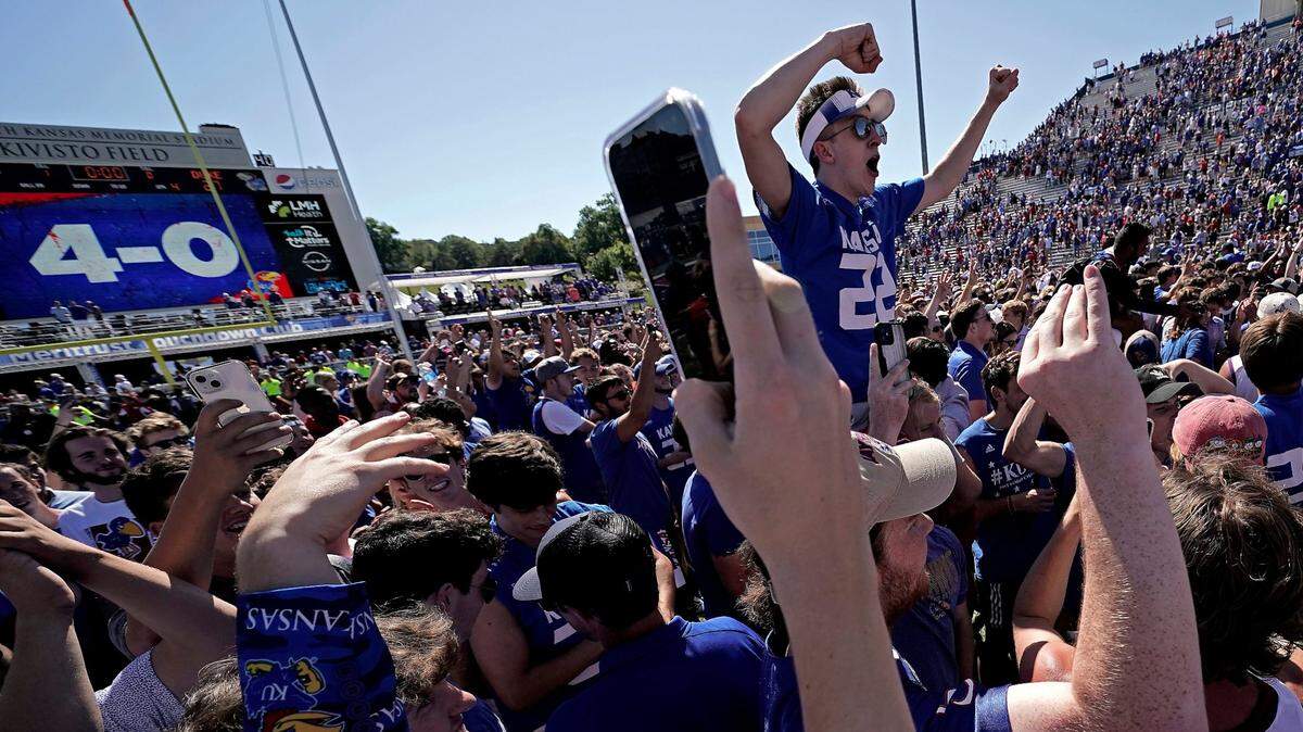 Giddy fans celebrate on the field after their Kansas Jayhawks beat the Duke Blue Devils 35-27 in Lawrence. KU improved to 4-0 with the Saturday afternoon victory but didn’t crack AP’s Top 25.