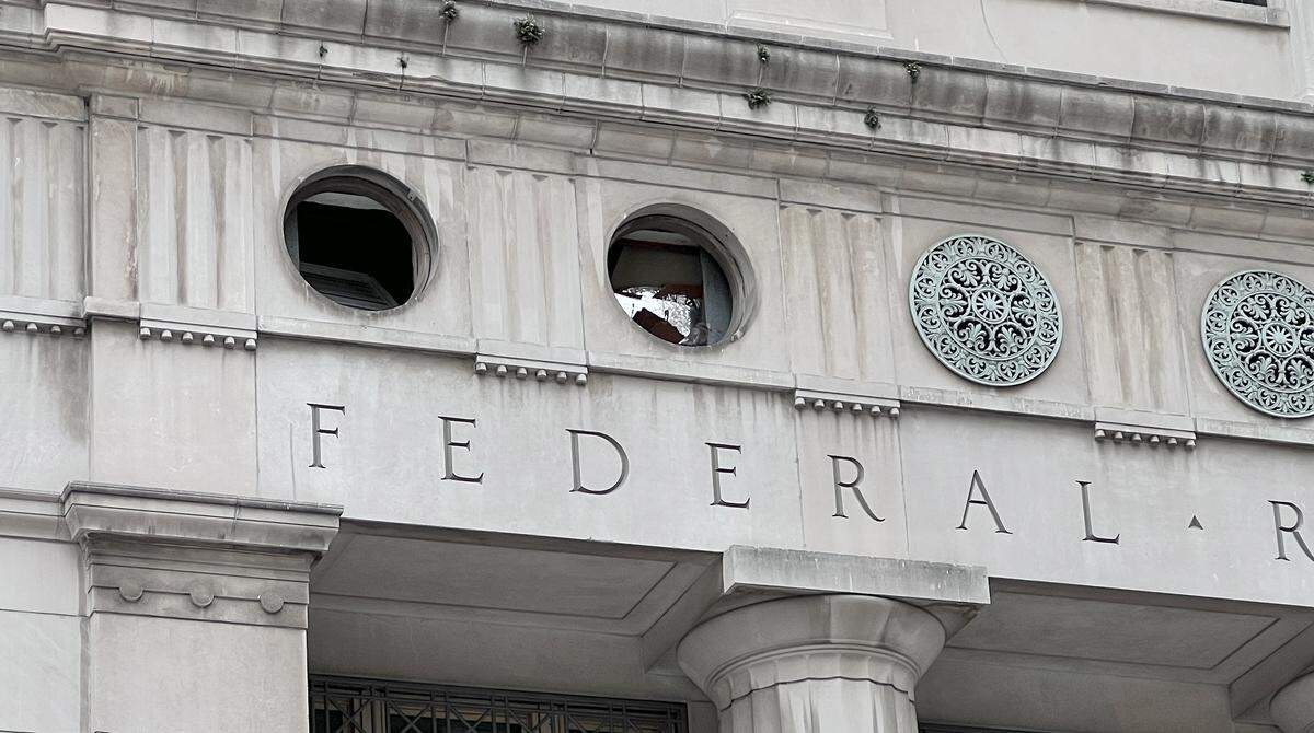 The historic Federal Reserve building at 925 Grand shows crumbling details and weathered stonework after sitting empty for over a decade, following an abandoned redevelopment project.