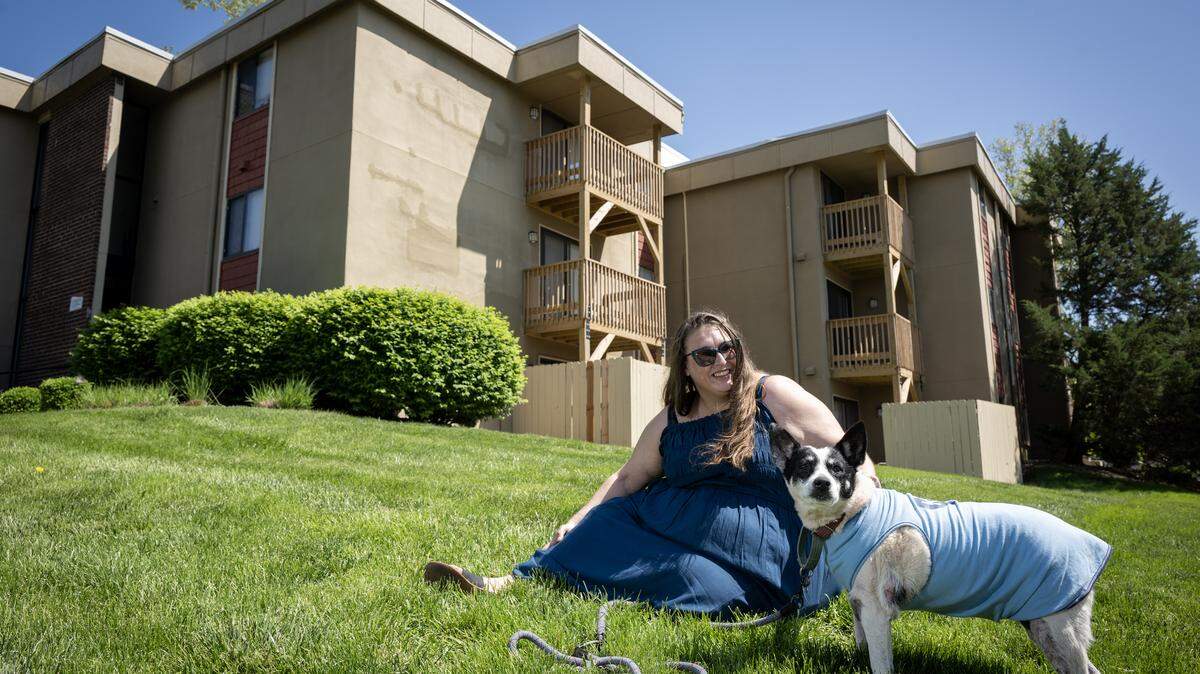 Jessica Ecord spends some time in the green space outside of her apartment with her dog, Ana, on Friday, May 9, 2025, in Lenexa, Kansas.  Ecord has lived in the Section 8 apartment since September of 2021. 