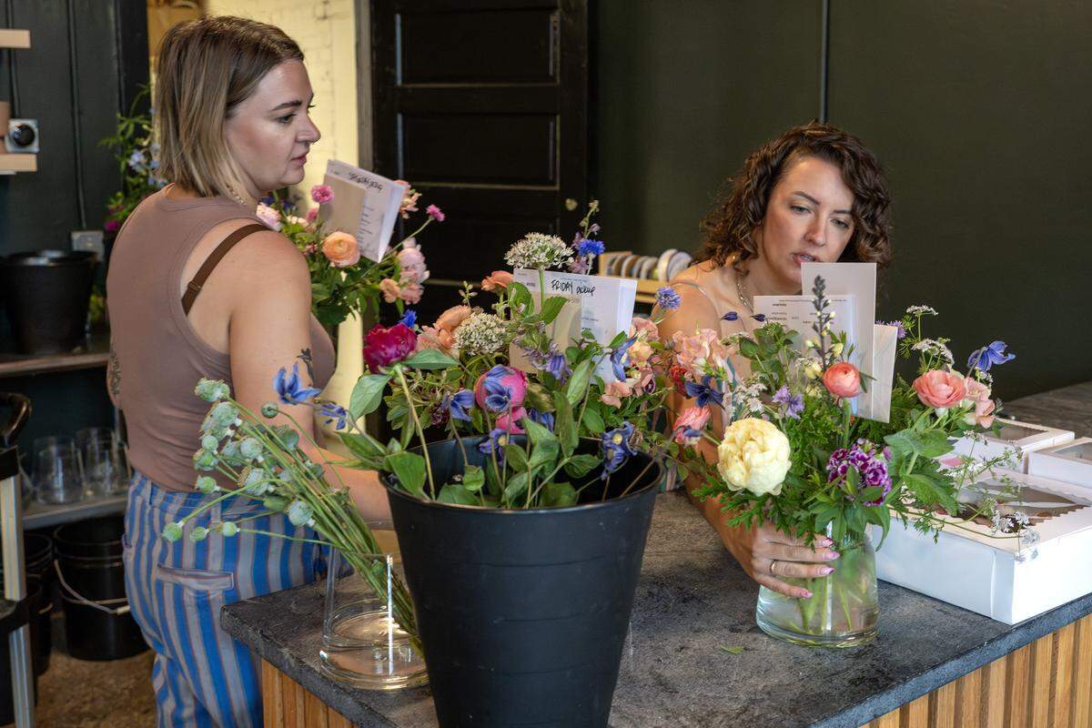 Betsy Ford, left, and Lily Williams, co-owners of Lily Floral Collective, arrange bouquets of flowers at the shop on Friday, May 8, 2026, in Kansas City.