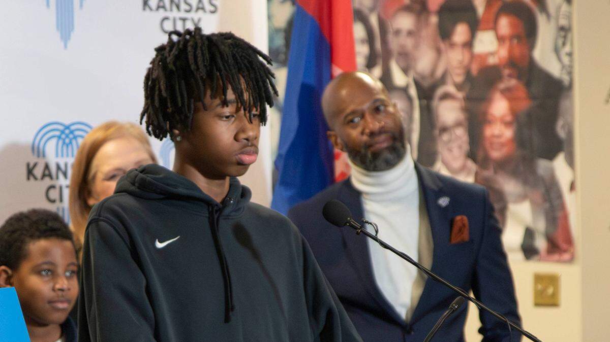 Toriano Porter, right, looked on as his child Giulian Williams’ new hotline was announced Feb. 5.