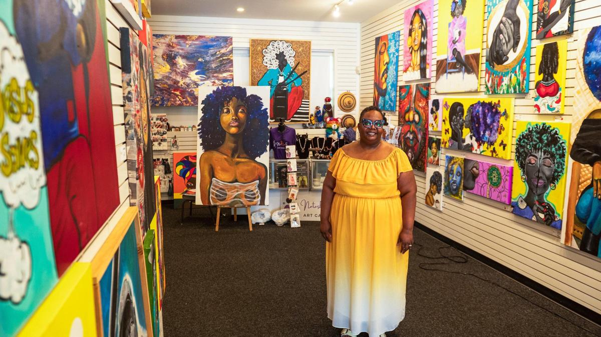 Natasha El-Scari stands inside her gallery, surrounded by Black art, at 1014 W. 39th St.