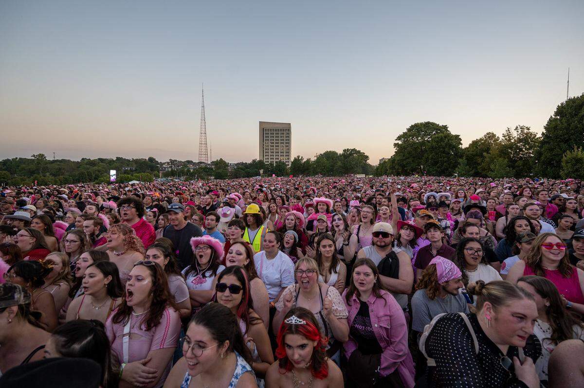 Fans, many dressed in pink, fill the lawn of the National WWI Museum and Memorial as they await Chappell Roan performance during her Visions of Damsels and Other Dangerous Things tour stop on Friday, Oct. 3, 2025, in Kansas City.