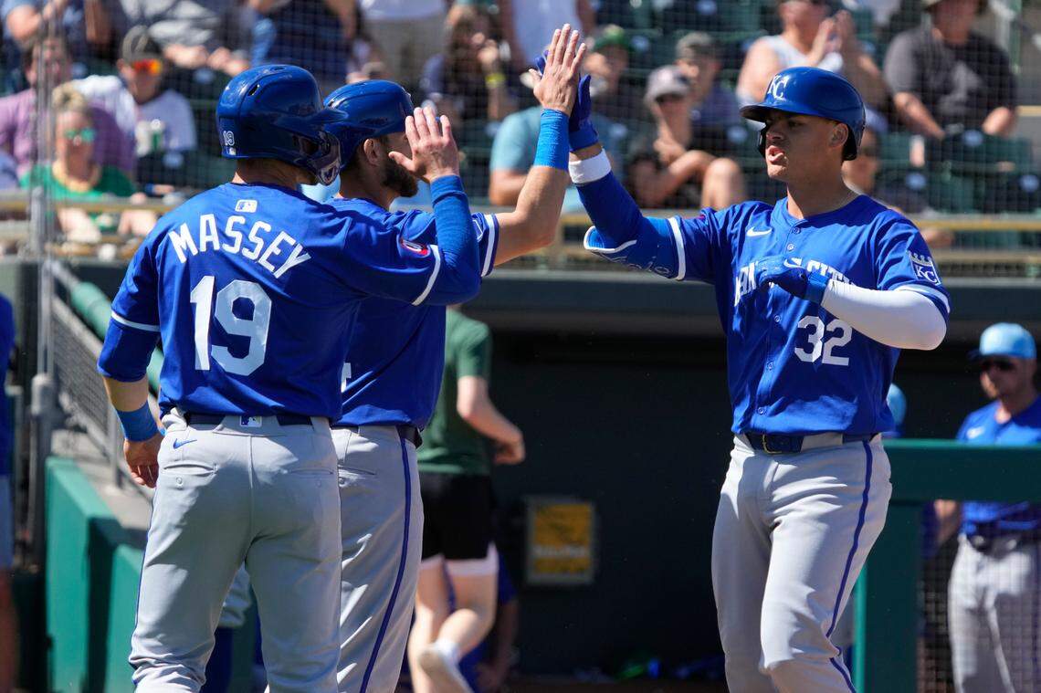 Kansas City Royals first baseman Nick Pratto (32) celebrates with catcher Austin Nola (14) and second baseman Michael Massey (19) after hitting a three-run home run against the Oakland Athletics in the second inning at Hohokam Stadium on March 10, 2024.