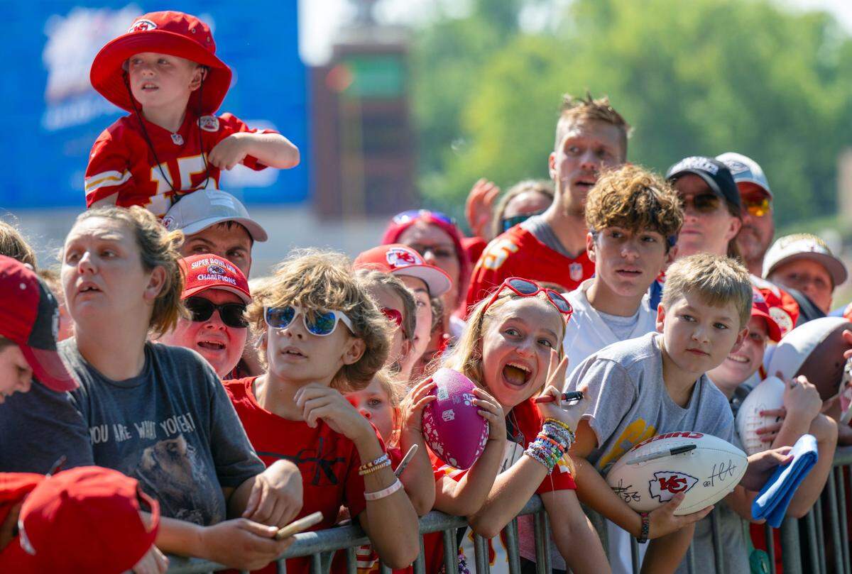Fans at the Chiefs training camp in St. Joseph gather along a fence in hopes of getting players’ autographs.